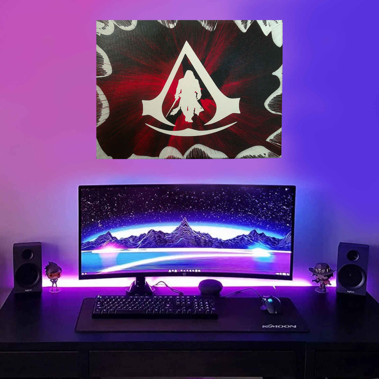 Assassin's Creed spin art canvas above a computer monitor with mountain-themed wallpaper, keyboard, and speakers on a desk with a colorful LED light background.