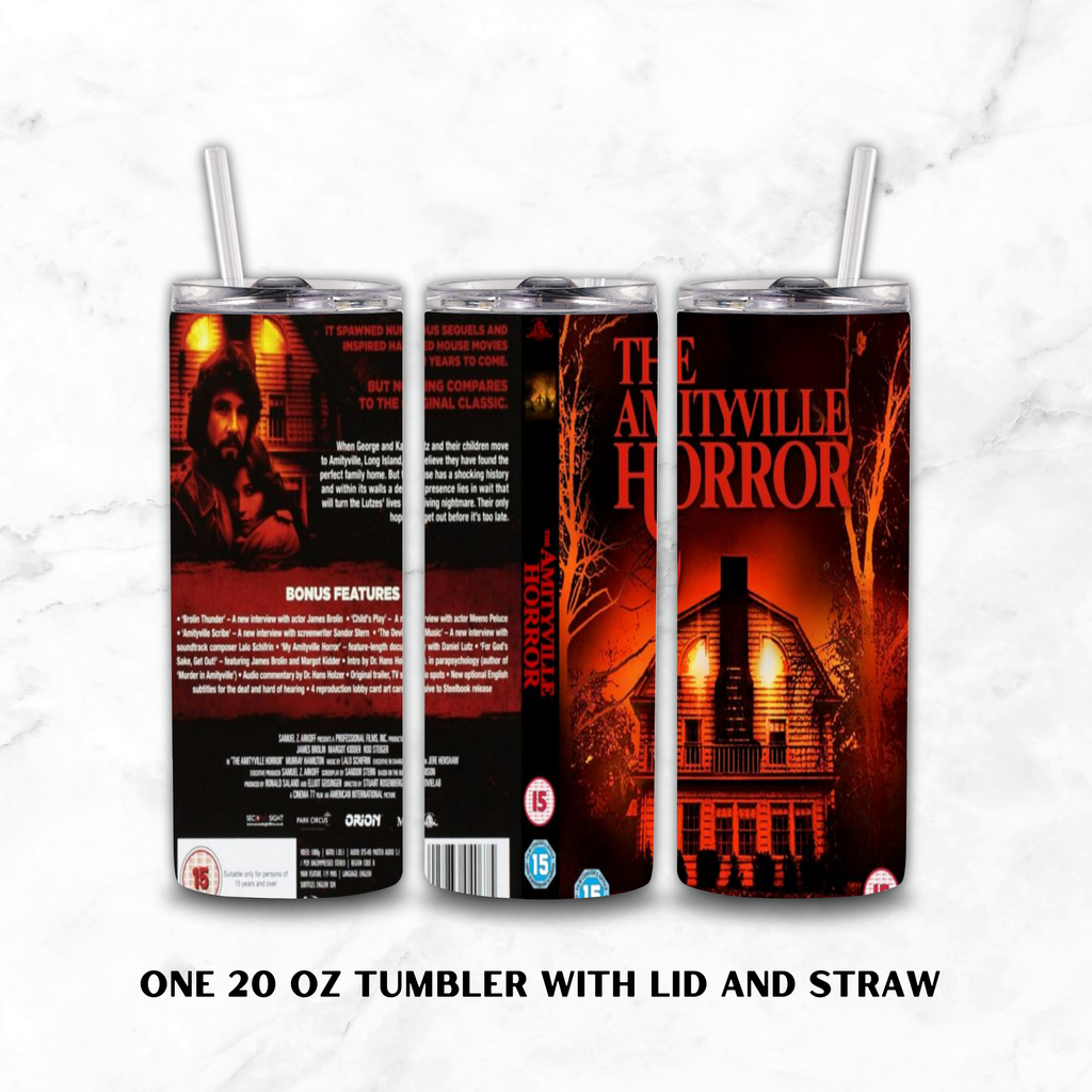Three views of a 20 oz skinny tumbler with lid and straw, featuring a horror movie wrap design. The design displays the back, front, and spine of the tumbler with a dark red and black theme, showing a man's face, the title 'The Amityville Horror', and a haunted house illustration.