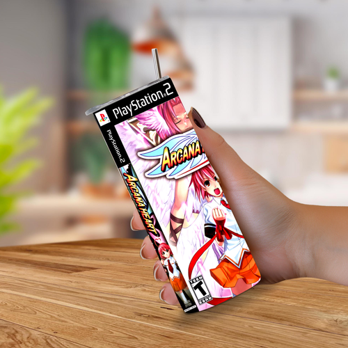 A hand holding a 20oz tumbler PlayStation 2 game designed with Arcana Heart, on a wooden table with a blurred indoor background.