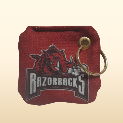 Red keychain pouch with 'Razorbacks' logo on a beige background