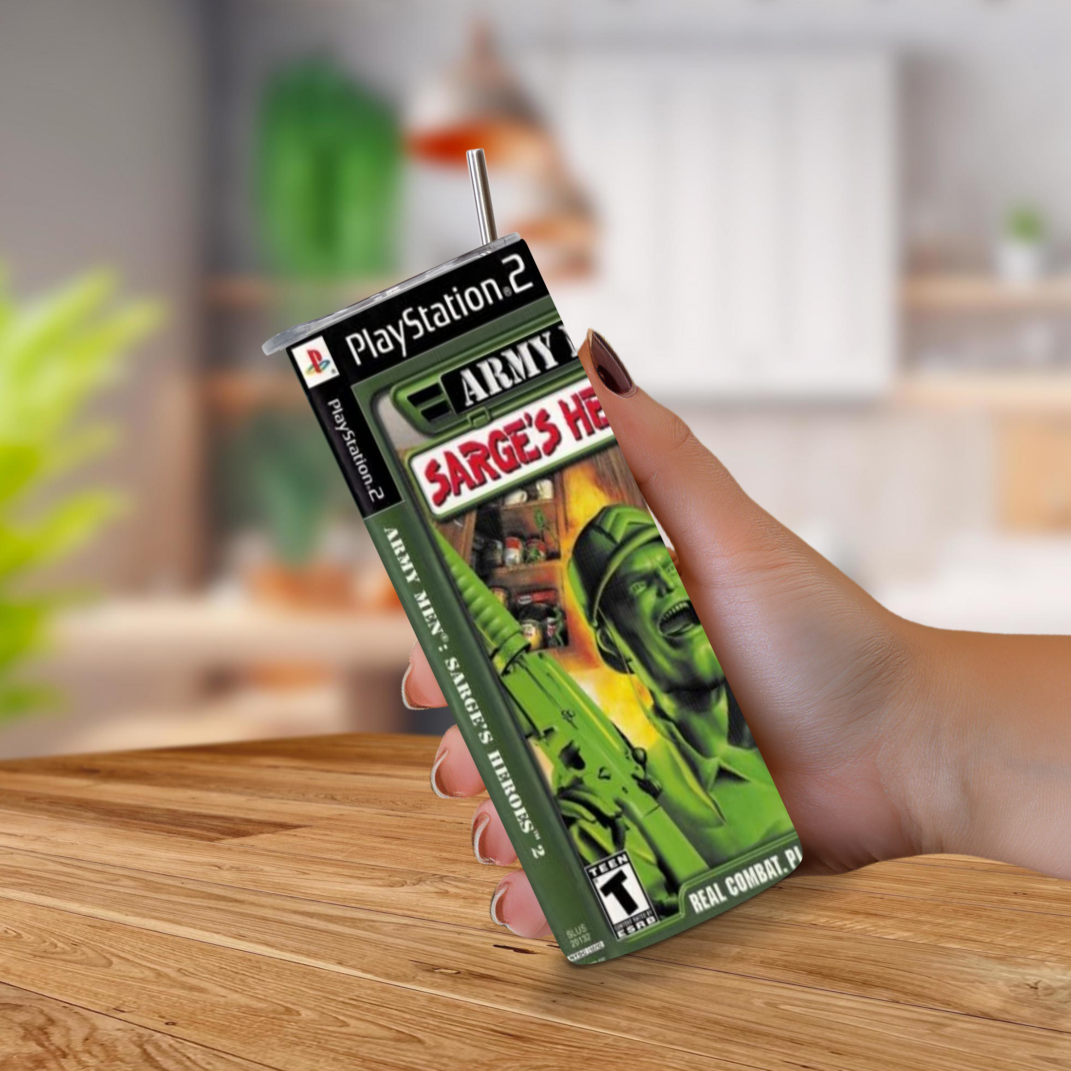 A hand holding a 20oz tumbler designed PlayStation 2 game with the title 'Army Men Sarge's Hero' and green military artwork, set against a blurred indoor background.