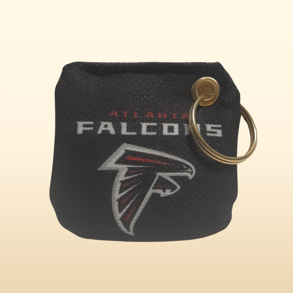 Black keychain pouch with Atlanta Falcons logo on a beige background