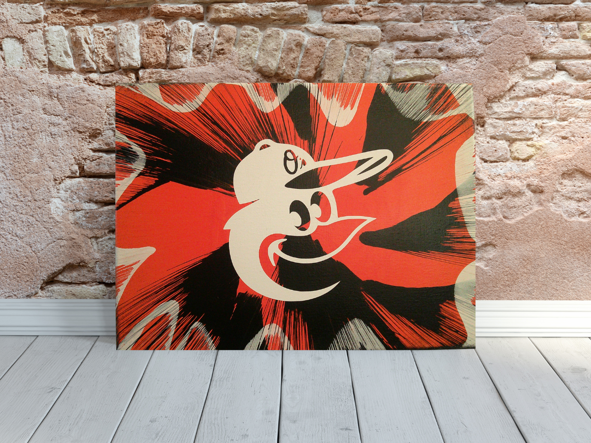 Baltimore Orioles Spin Art canvas wall art leaning against a brick wall.