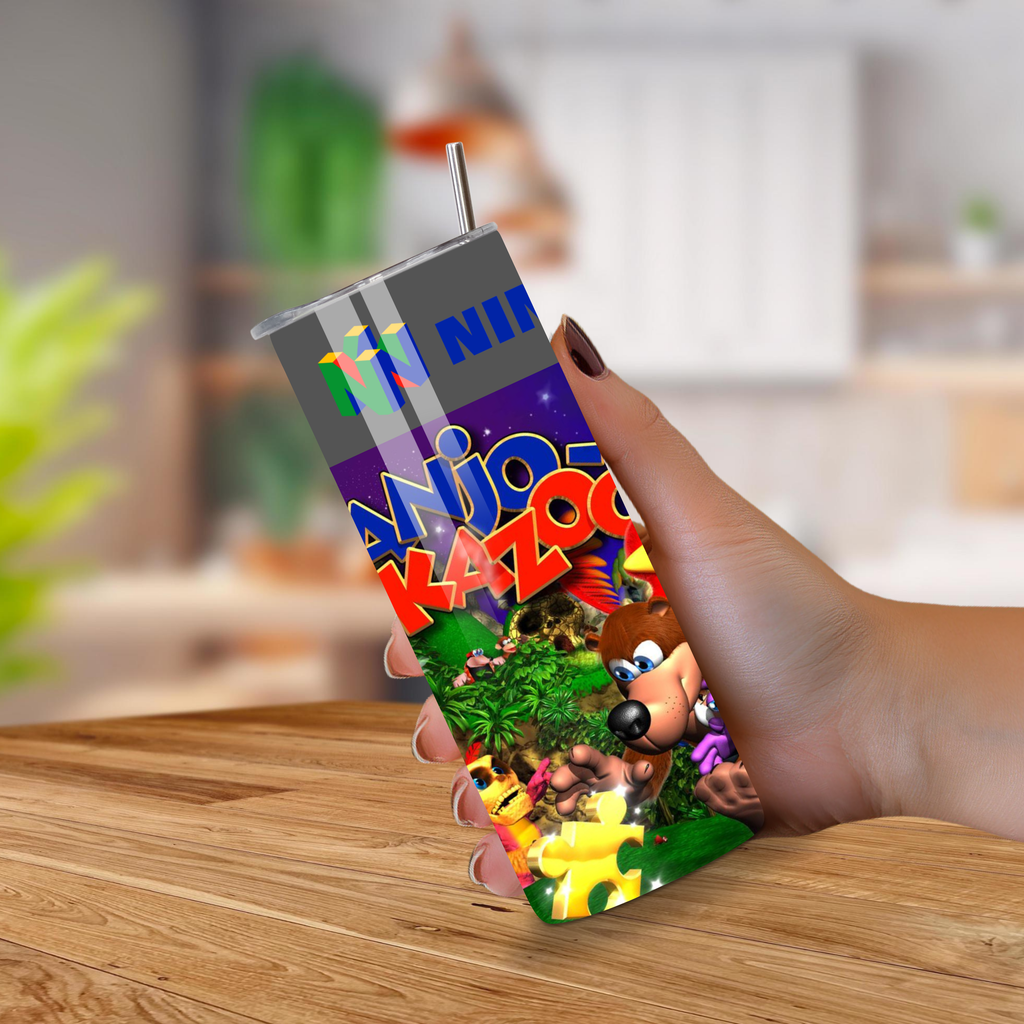 Hand holding a 20oz tumbler with 'Banjo Kazooie' branding on a wooden surface.