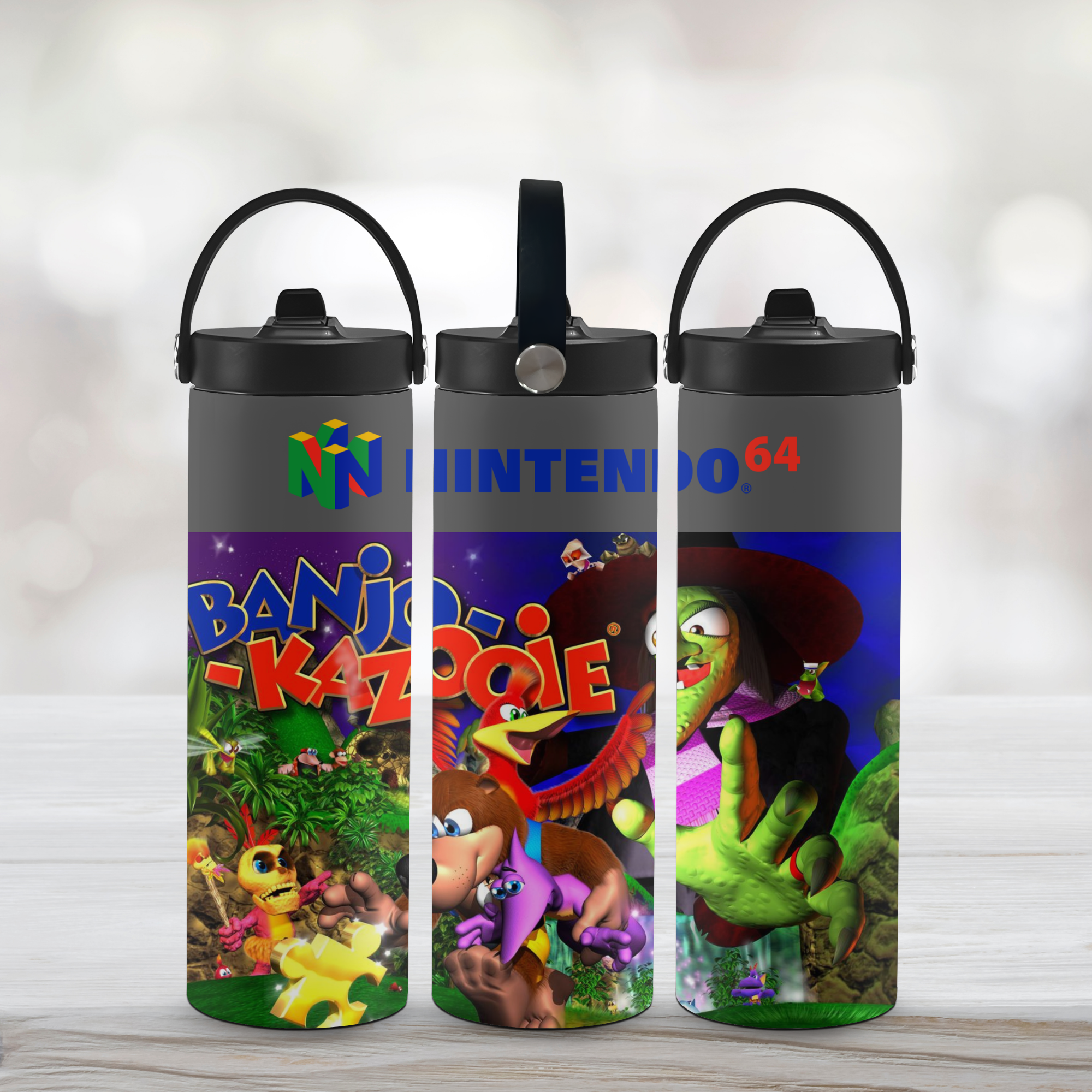 Three 'Banjo-Kazooie' branded sport water bottles with colorful graphics on a light background