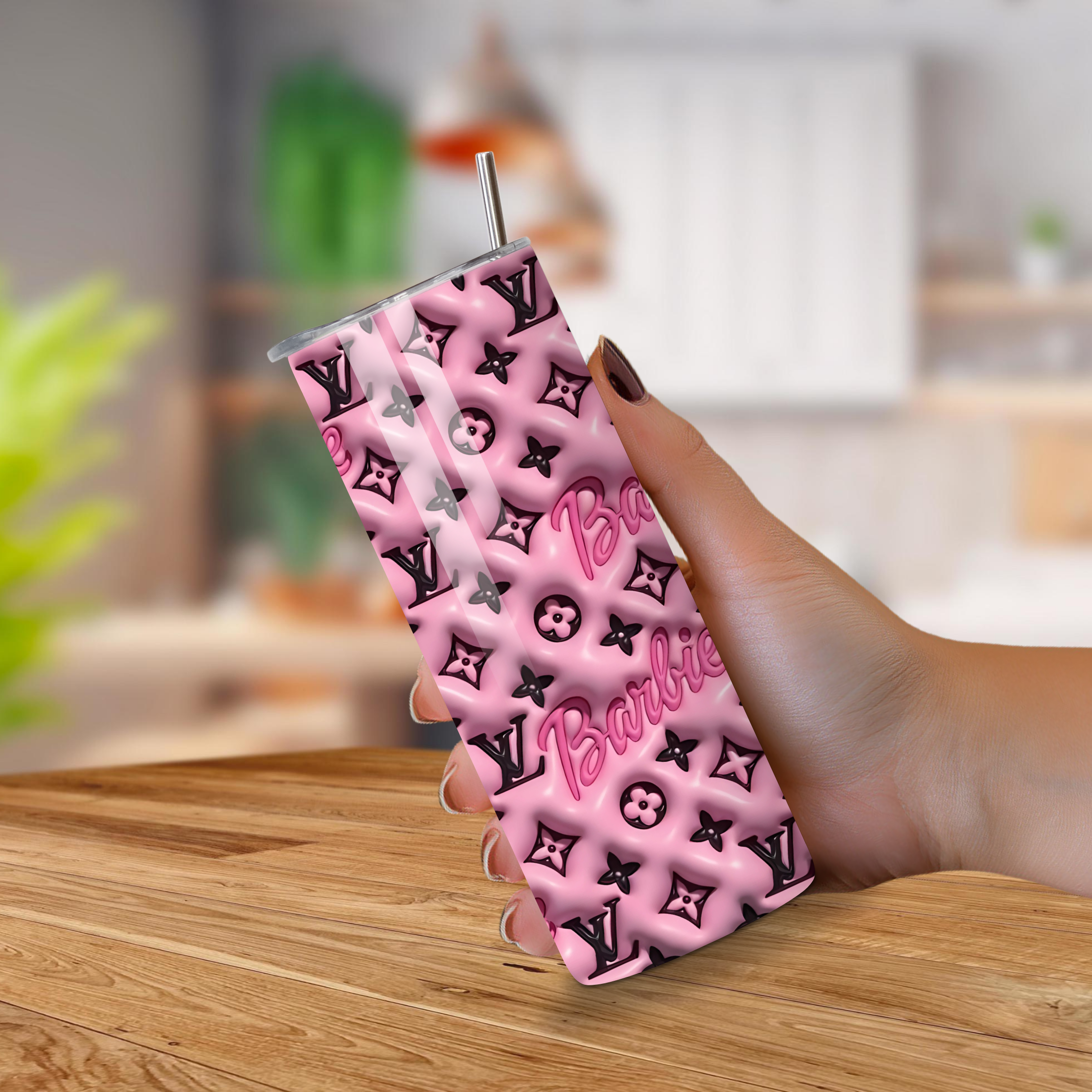 Pink and black patterned tumbler with 'Barbie' branding held by a hand on a wooden surface.