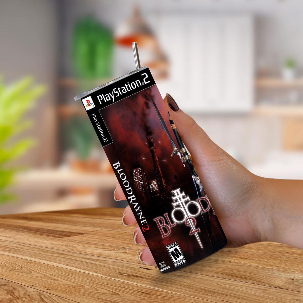 A hand holding a PlayStation 2-themed 20oz stainless steel tumbler with a straw, featuring the Bloodrayne 2 video game cover art, set against a blurred indoor background.