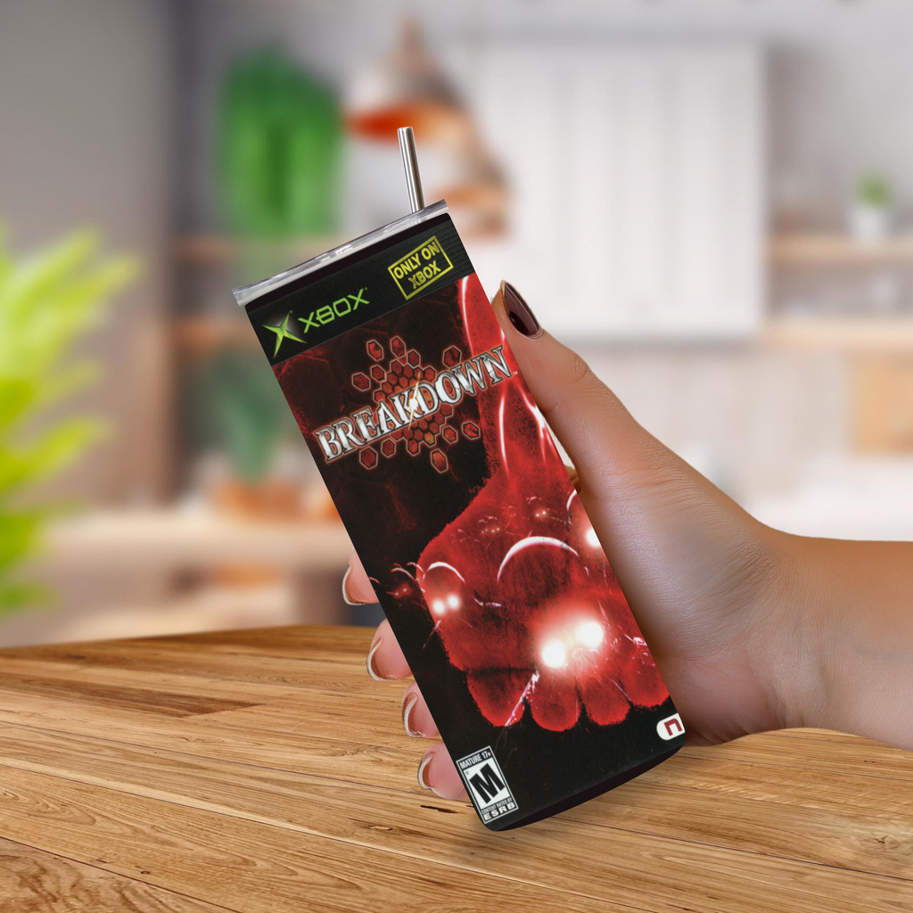 A hand holding a novelty Xbox-branded tumbler cup designed to look like the 'Breakdown' game, with a straw, against a blurred kitchen background.