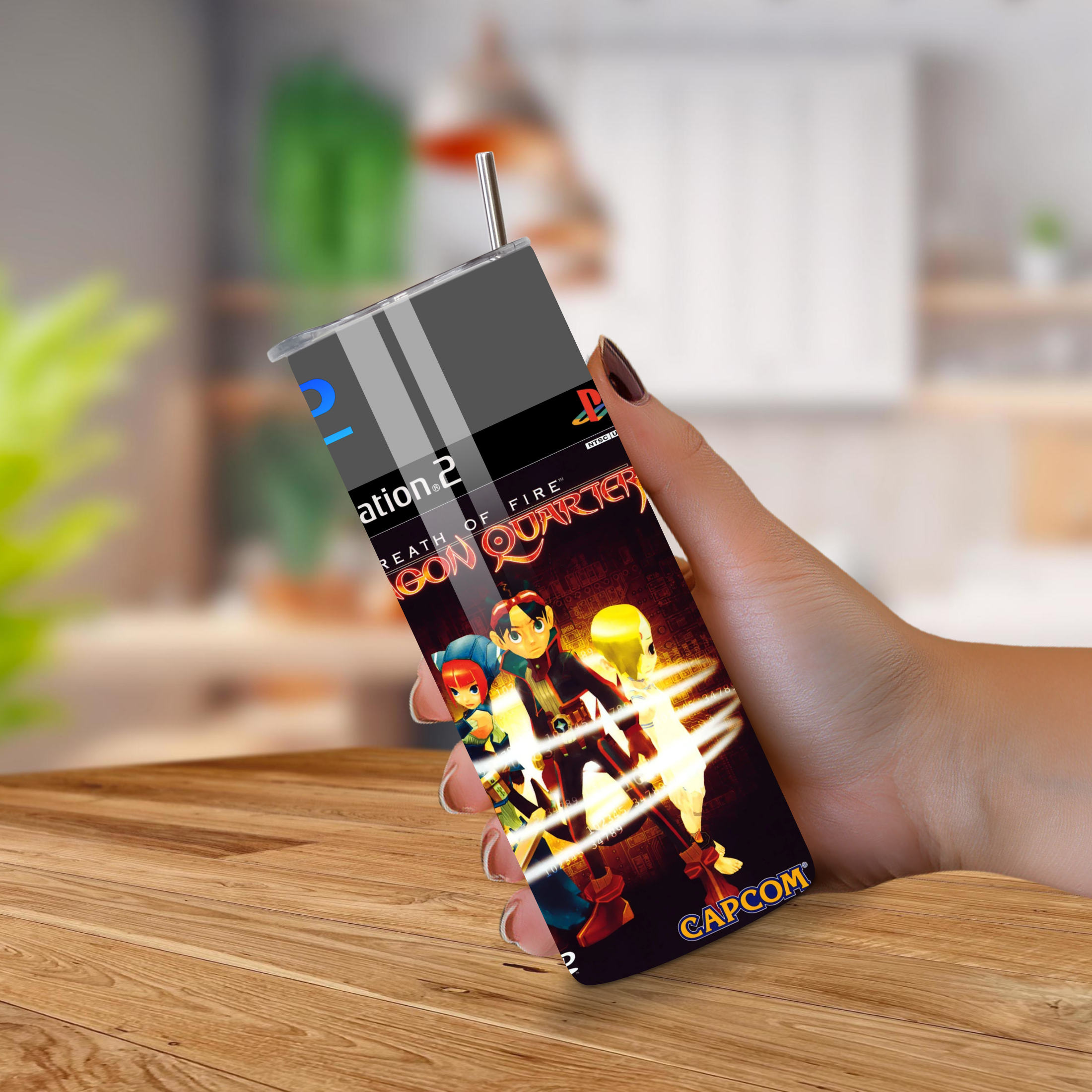 Person holding a 20oz tumbler with a breath of fire design on a wooden table.