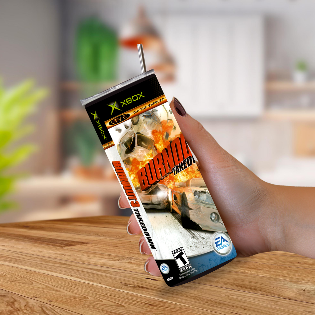 A hand holding a 20oz tumbler of the Xbox One game for Burnout 3: Takedown featuring a printed cover with flames and the Xbox and EA logos, set against a blurred indoor background.