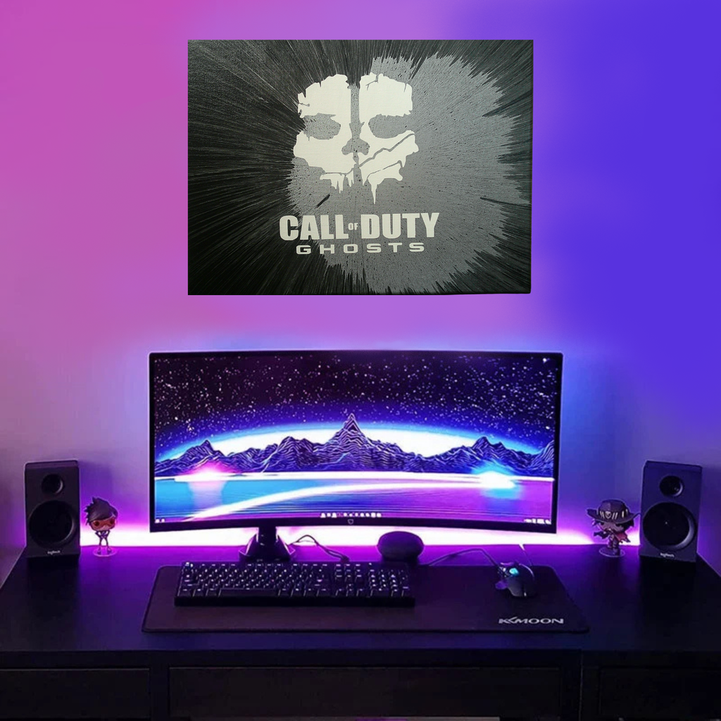 Computer setup with Call of Duty spin art canvas above a monitor displaying a mountain landscape.