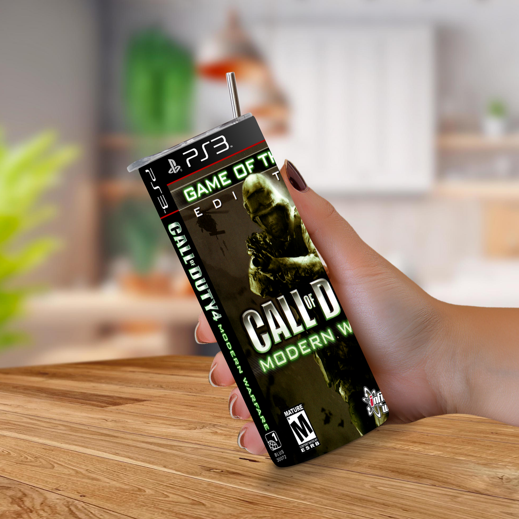 A hand holding a PS3-themed Call of Duty: Modern Warfare 2 20oz stainless steel tumbler with a straw, set against a blurred indoor background.