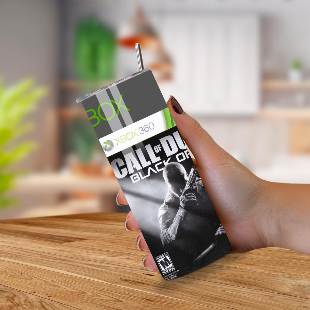 Hand holding a 20oz tumbler product with 'Call of Duty: Black Ops' branding on a wooden surface.