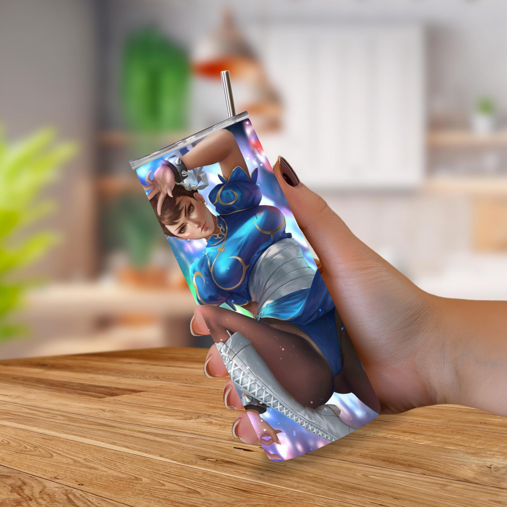 A hand holding a 20oz tumbler with a printed holographic anime-style character Chun-Li design, featuring a metal straw, set against a blurred indoor background.