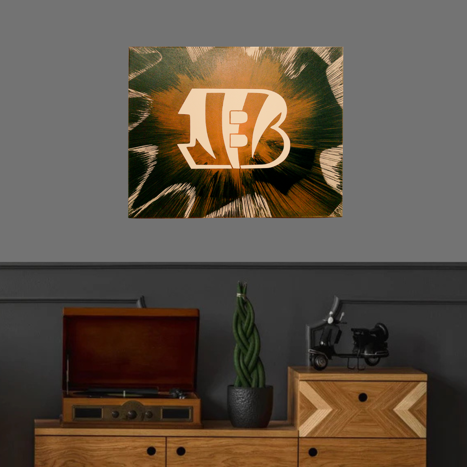 Cincinnati Bengals Spin Art above a wooden cabinet with a record player and decor items.