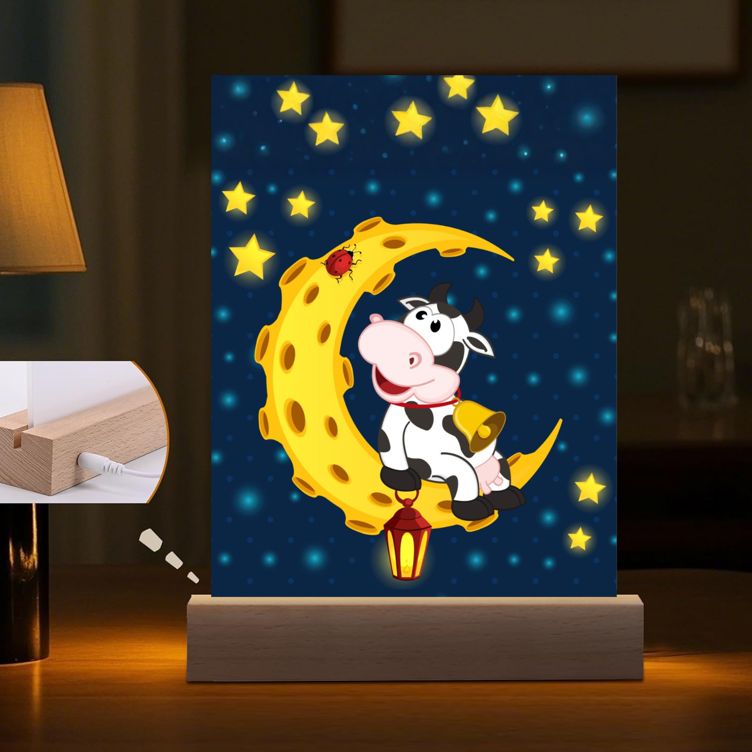 Cartoon cow on a moon-shaped night light with stars in the background