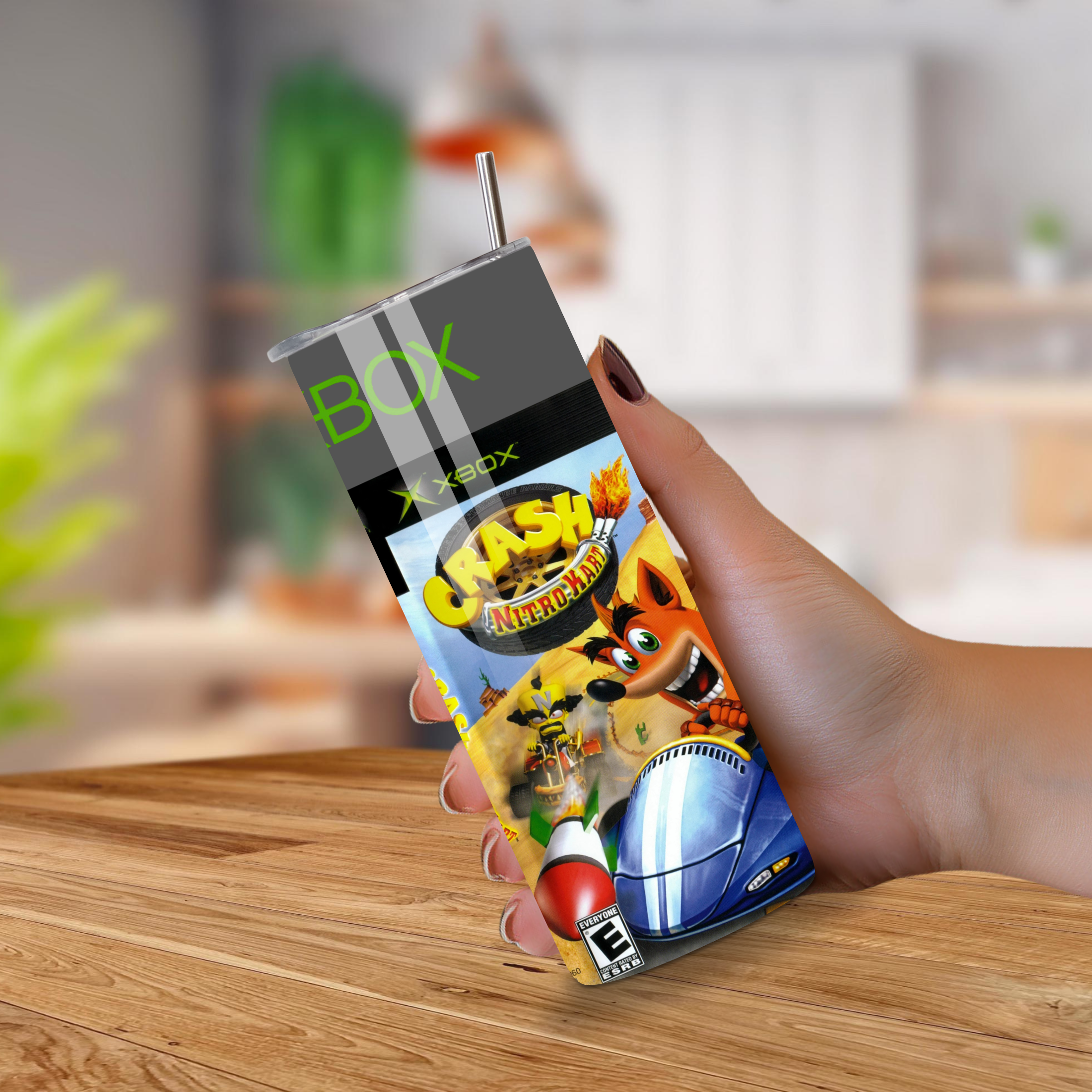 20oz tumbler with 'Crash Nitro Kart' design held by a hand on a wooden surface.