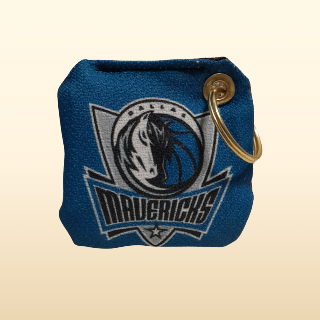 Blue keychain pouch with Dallas Mavericks logo on a beige background