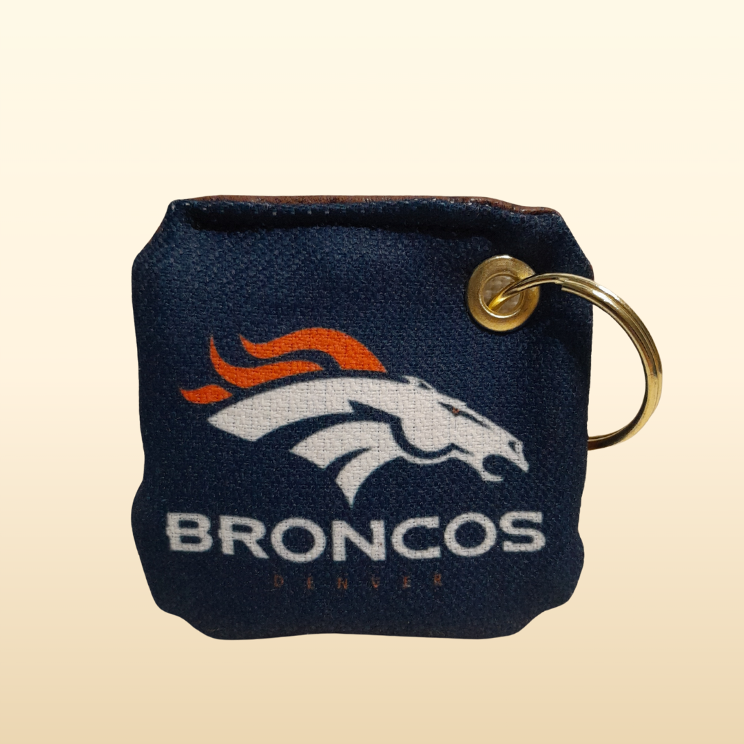 Keychain with Denver Broncos logo on a beige background