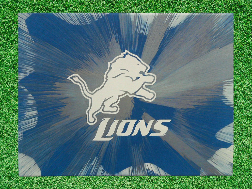 Detroit Lions Spin Art canvas wall art with a blue and gray background on grass
