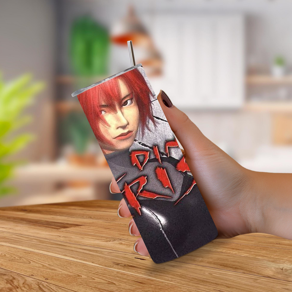 A hand holding a 20oz tumbler with artwork of a person with red hair and bold red Dino Crisis, photographed over a blurred indoor background with a wooden tabletop.