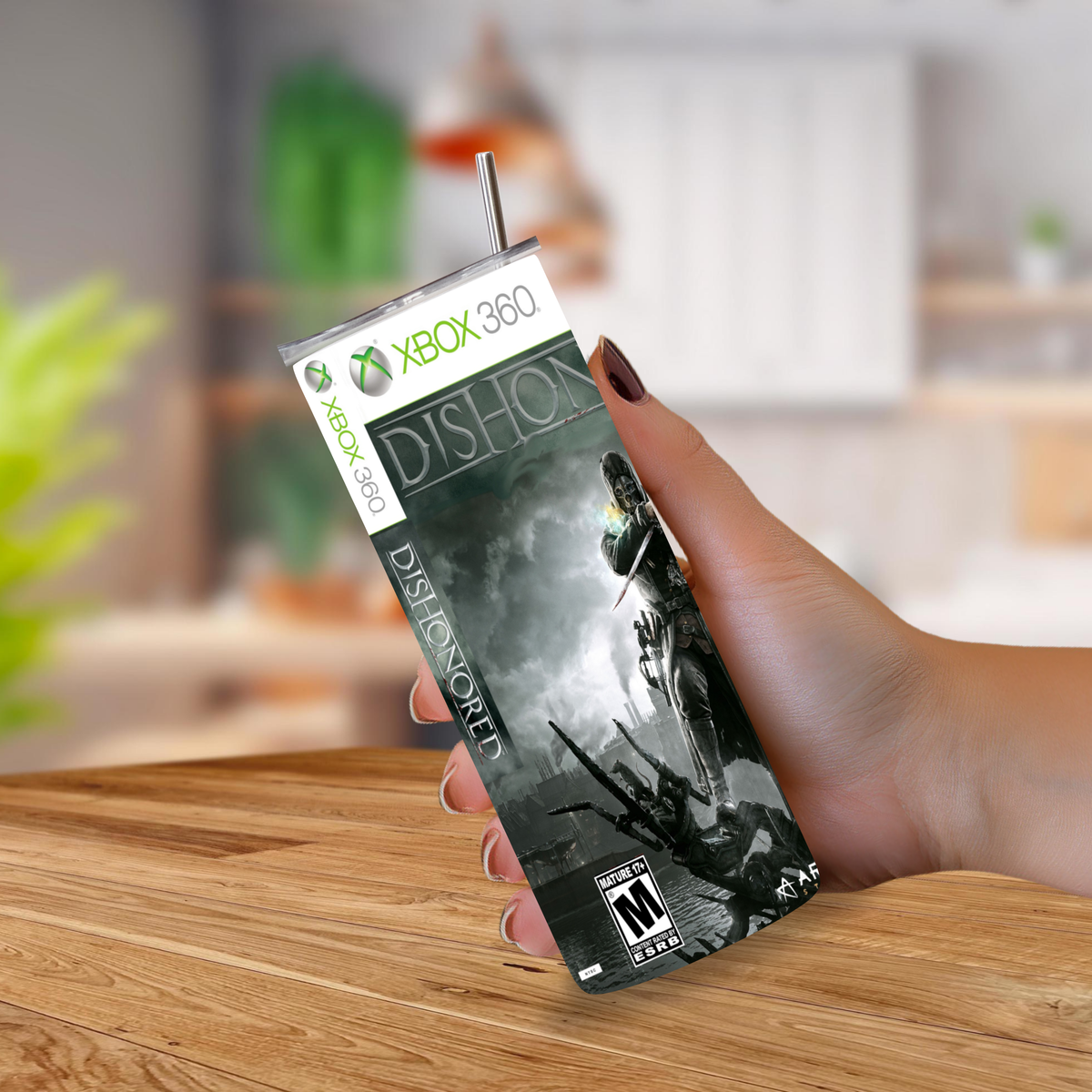 A hand holding a custom-designed, tumbler featuring the Xbox 360 with a printed graphic of a Dishonored.