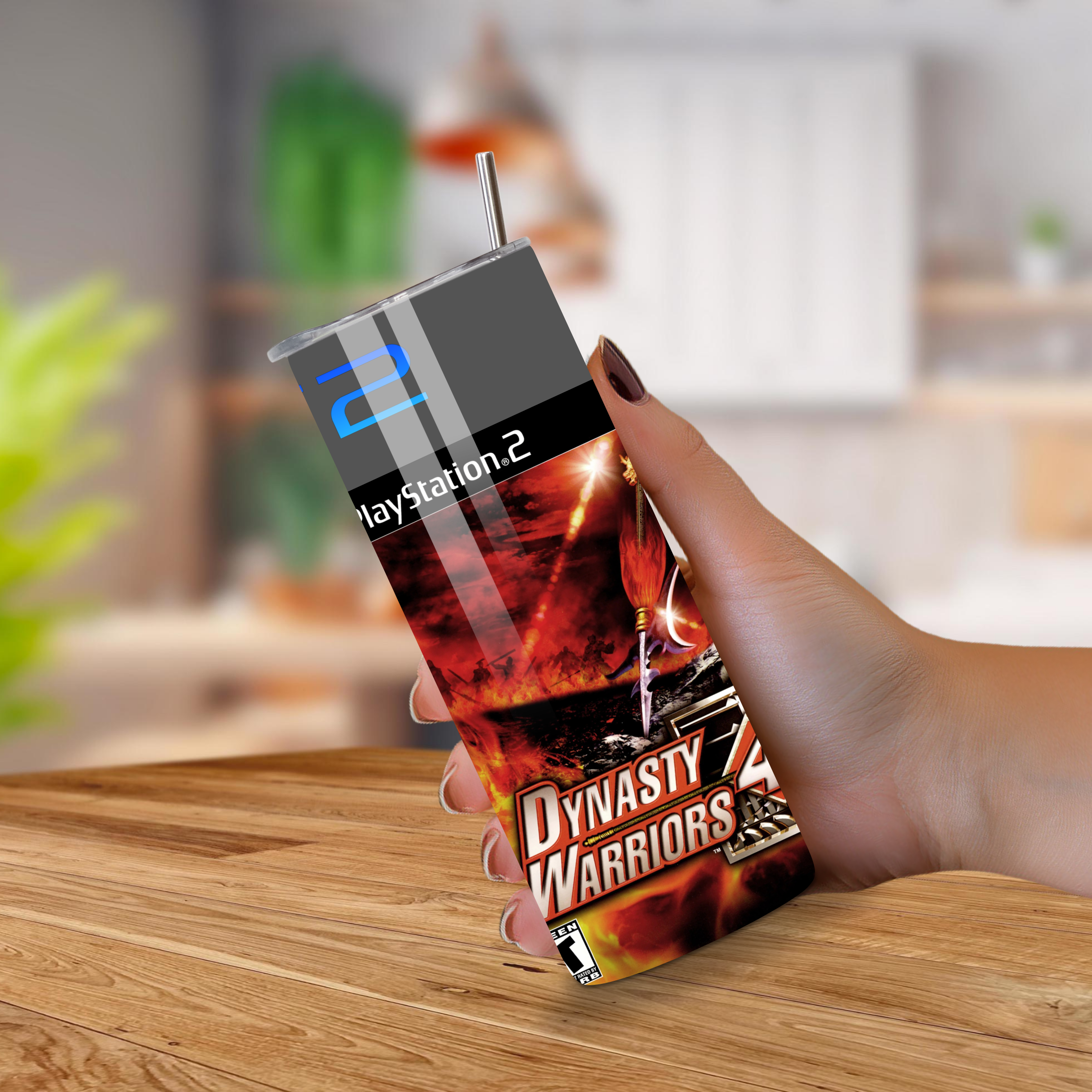 Tumbler with Dynasty Warriors 4 and PlayStation 2 design held by a hand on a wooden surface.