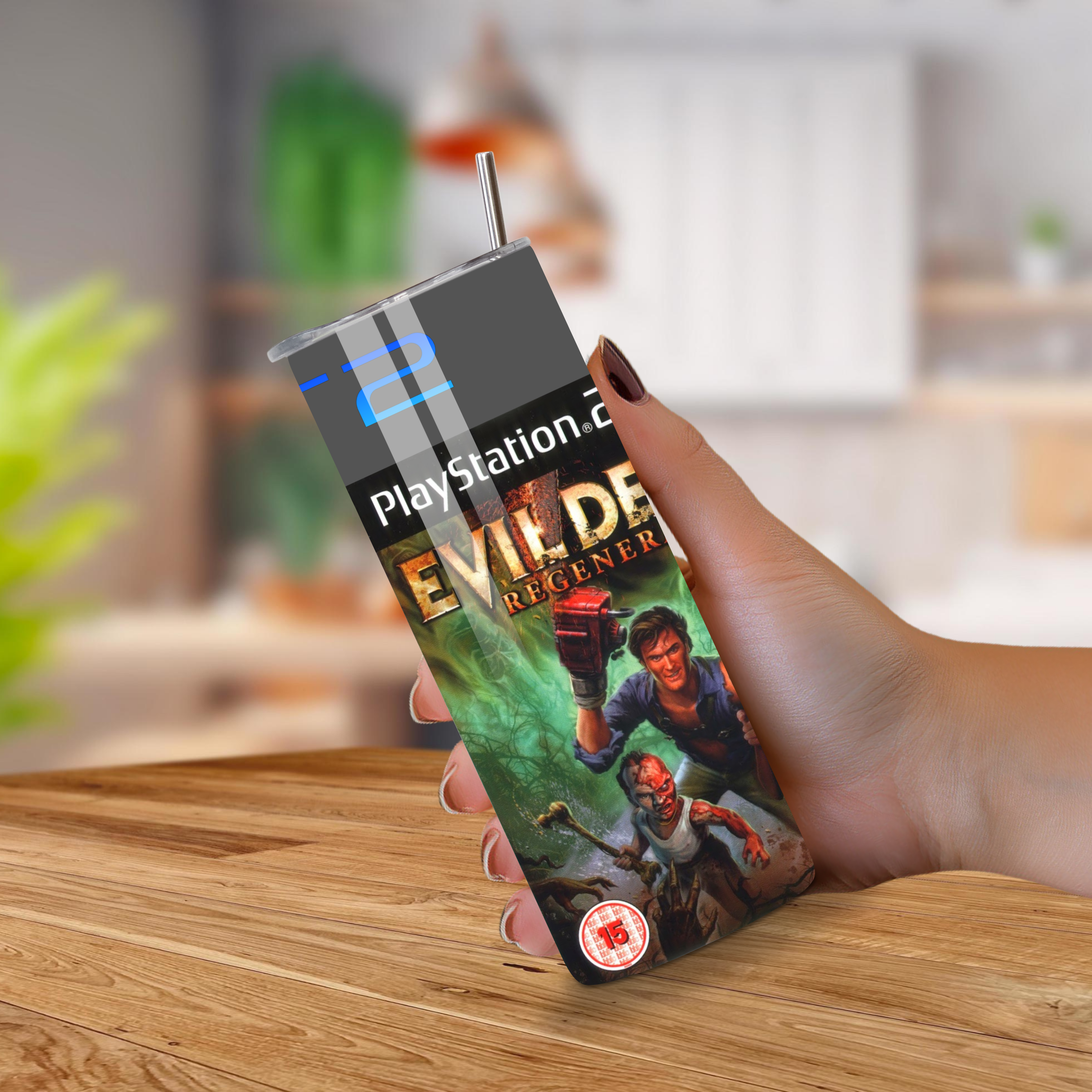 Evil Dead PlayStation 2-themed tumbler with game design held by a hand on a wooden surface.