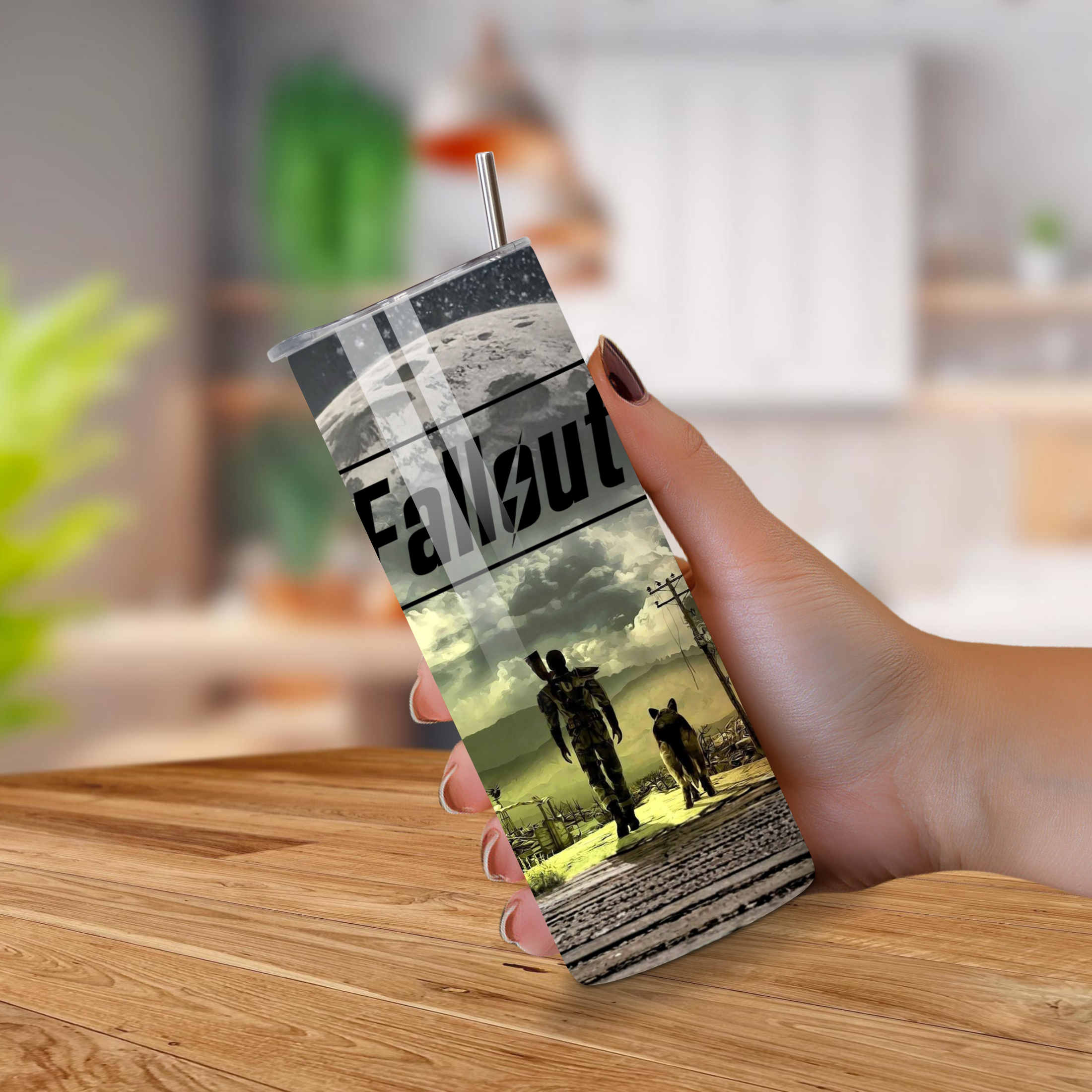 Tumbler with 'Fallout' design held by a hand on a wooden surface