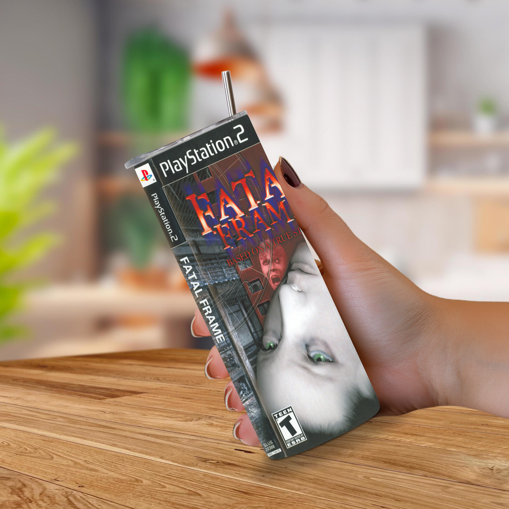 A hand holding a 20oz tumbler featuring the 'Fatal Frame' game cover art, set against a blurred kitchen background.