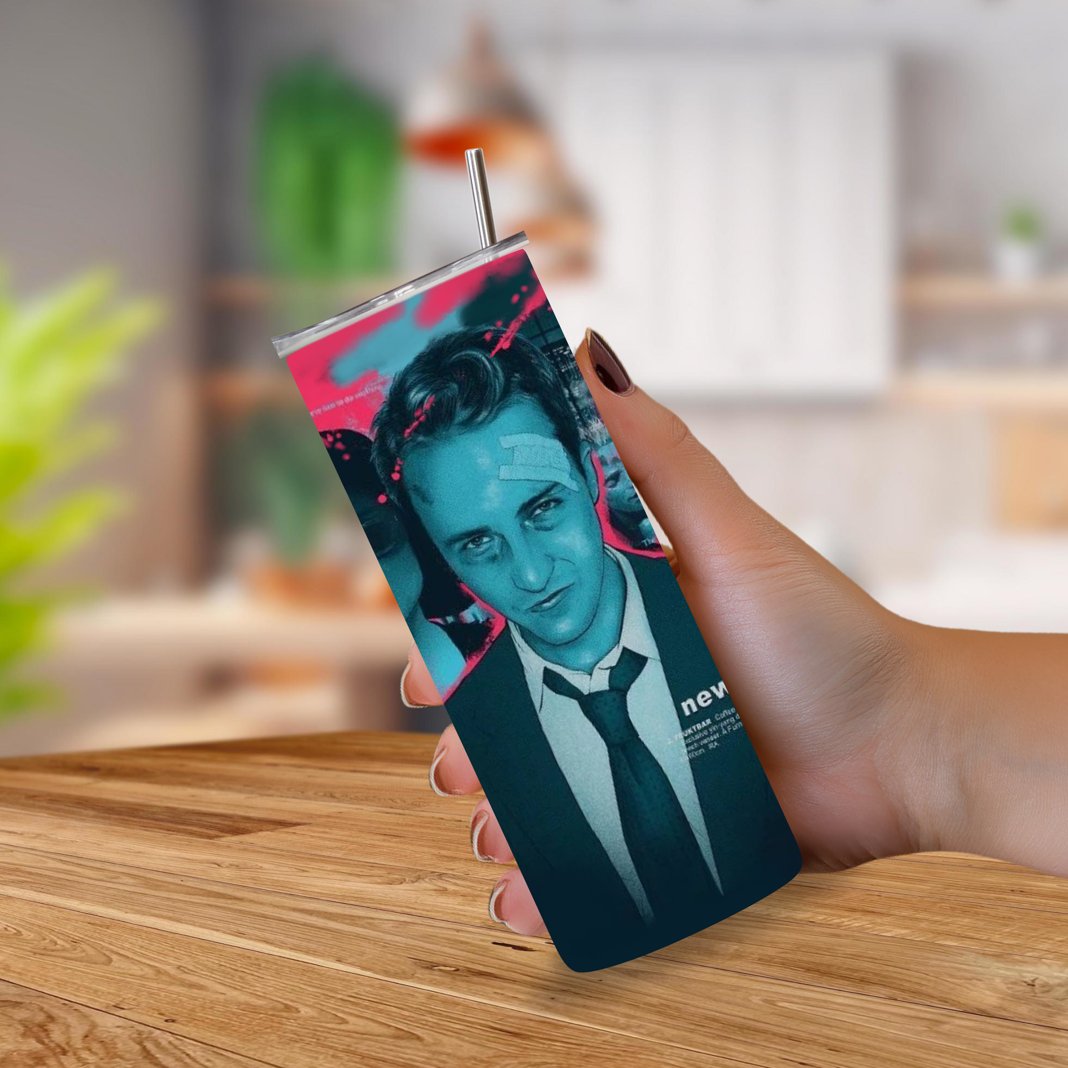 A hand holding a slim rectangular tumbler with a metal straw, featuring a stylized portrait of a man in a suit with teal, black, and pink graphic accents from the movie Fight Club, set against a blurred indoor background.