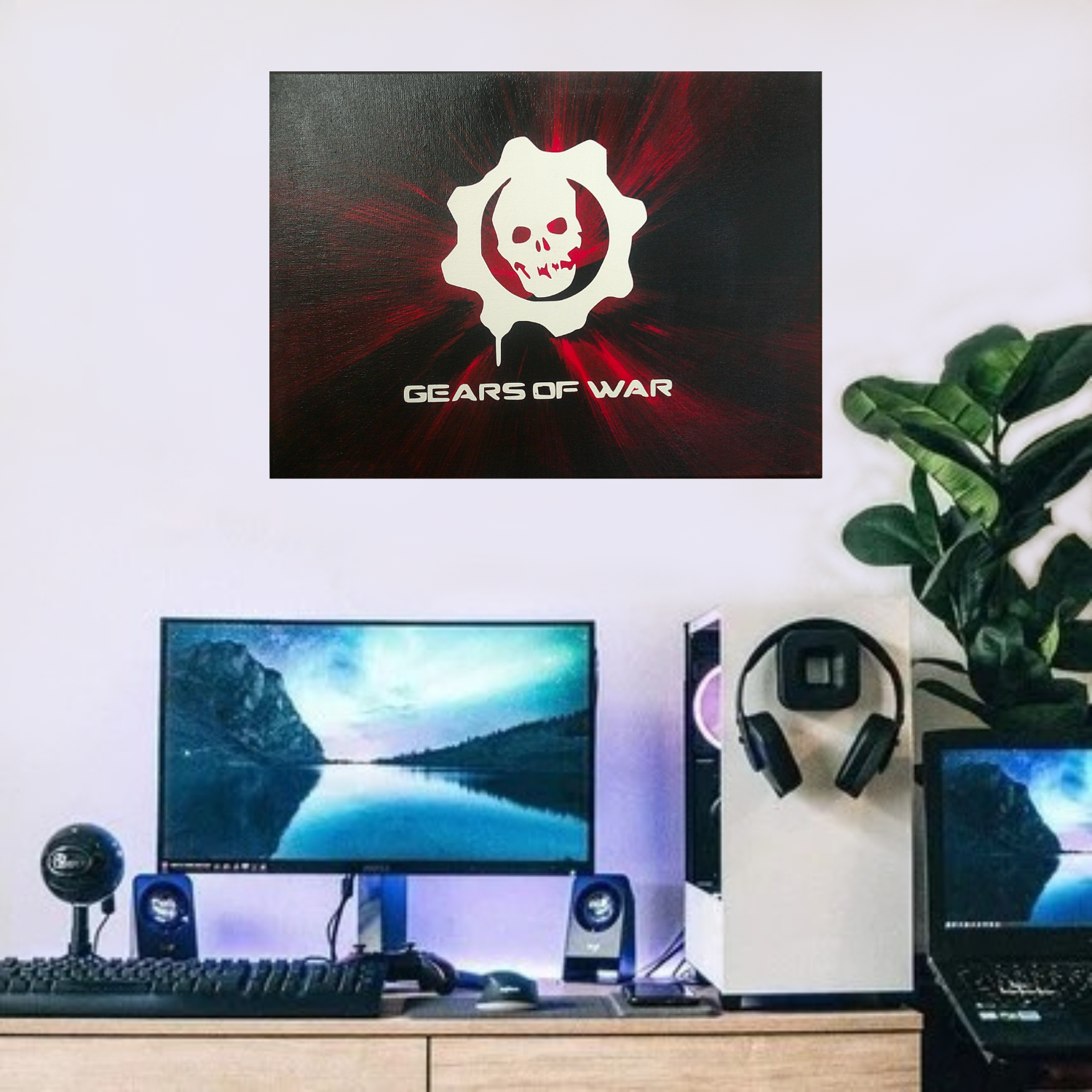 Gears of War spin art canvas above a monitor, keyboard, and speakers.