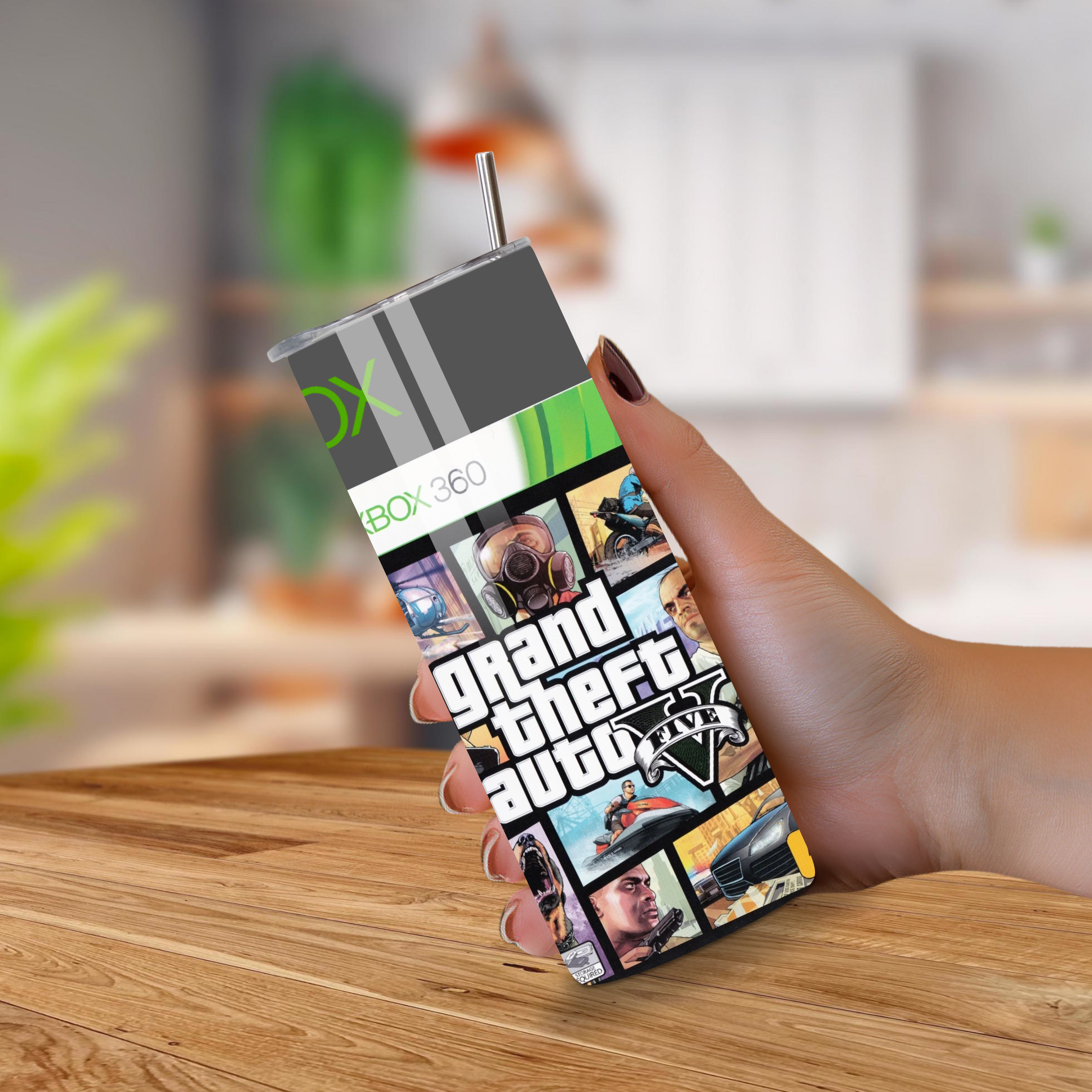 20oz tumbler with Grand Theft Auto V design held by a hand on a wooden surface