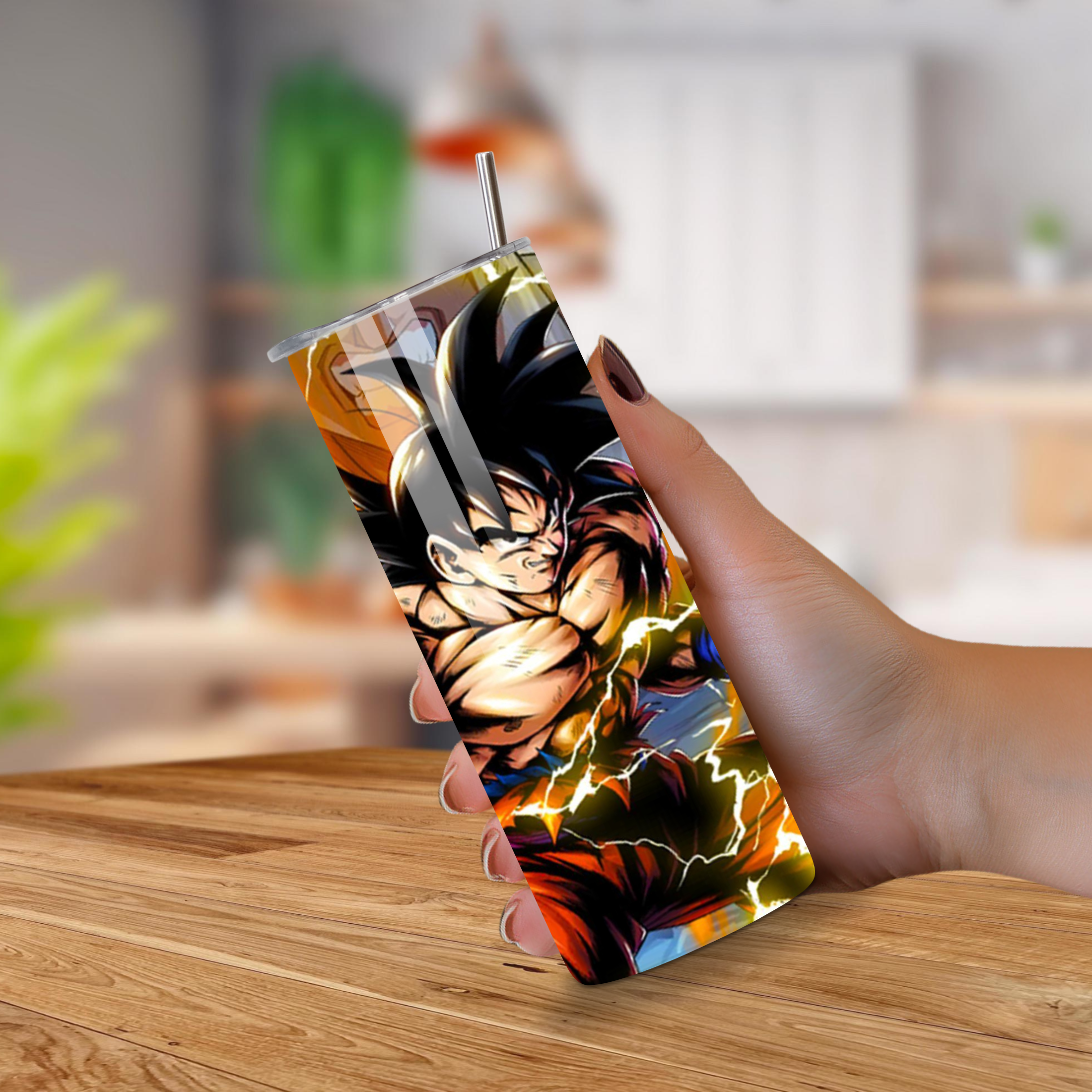 Person holding a colorful tumbler with a character Goku design on a wooden table.