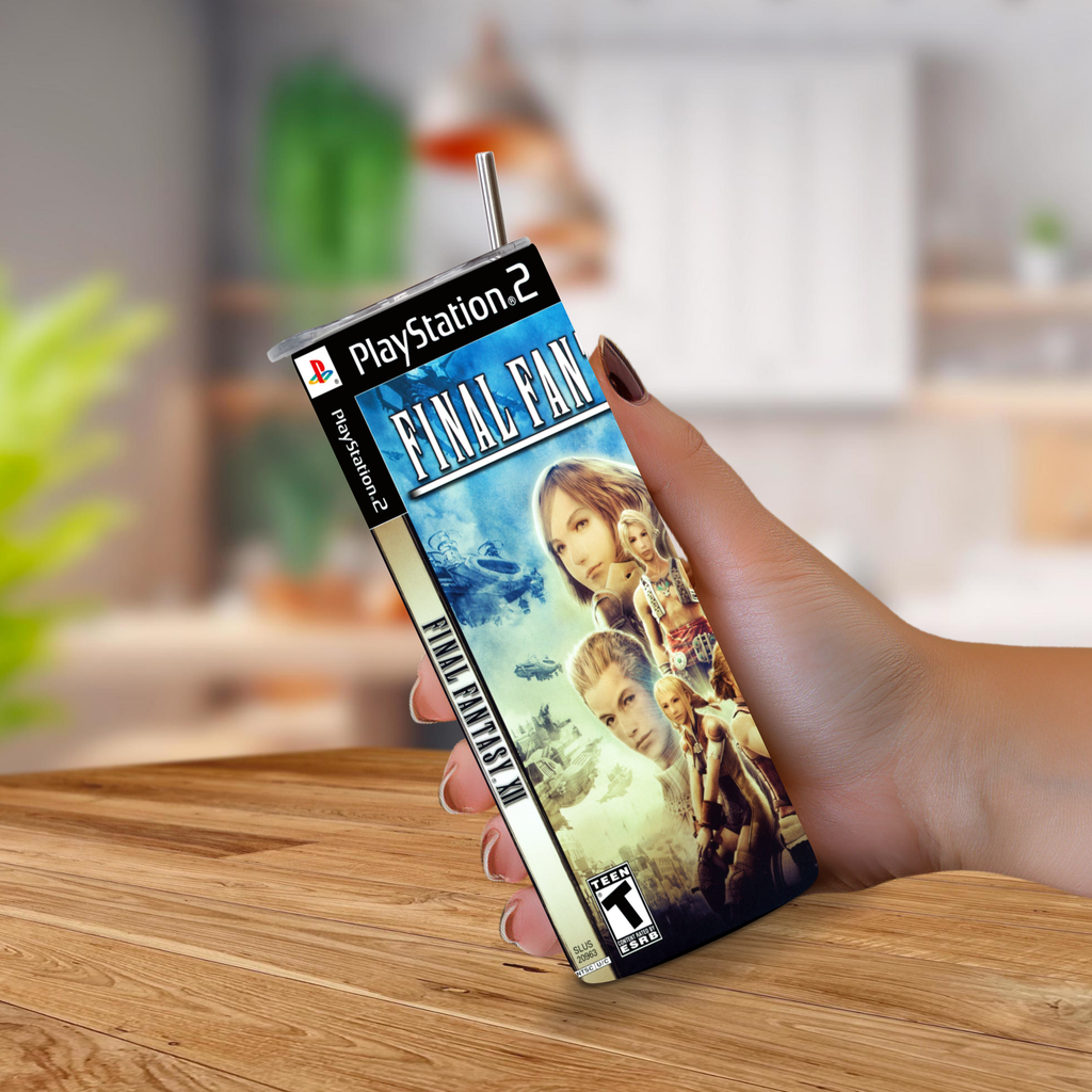 A hand holds a PlayStation 2 Final Fantasy XII 20oz stainless steel tumbler upright on a wooden tabletop, with a blurred indoor background behind it.
