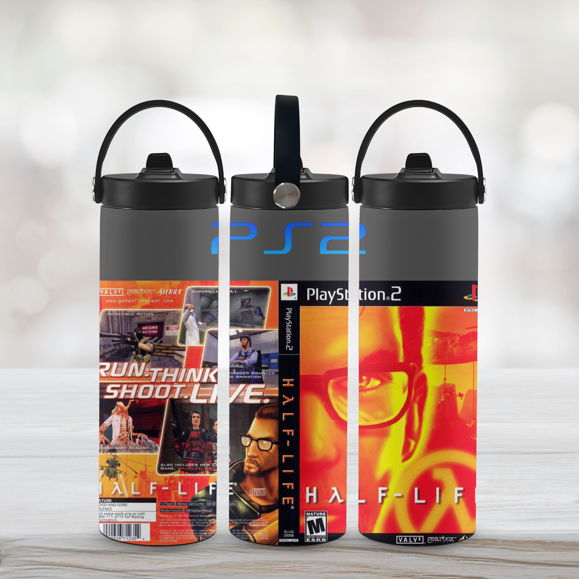 Three tumbler water bottles with PlayStation 2 and Half-Life designs on a light background