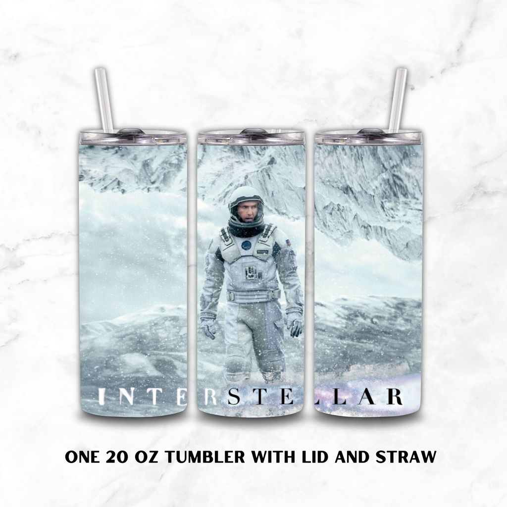Three views of a 20 oz insulated tumbler with lid and straw, featuring an 'Interstellar' astronaut design on a snowy mountain background, set against a white marble backdrop.