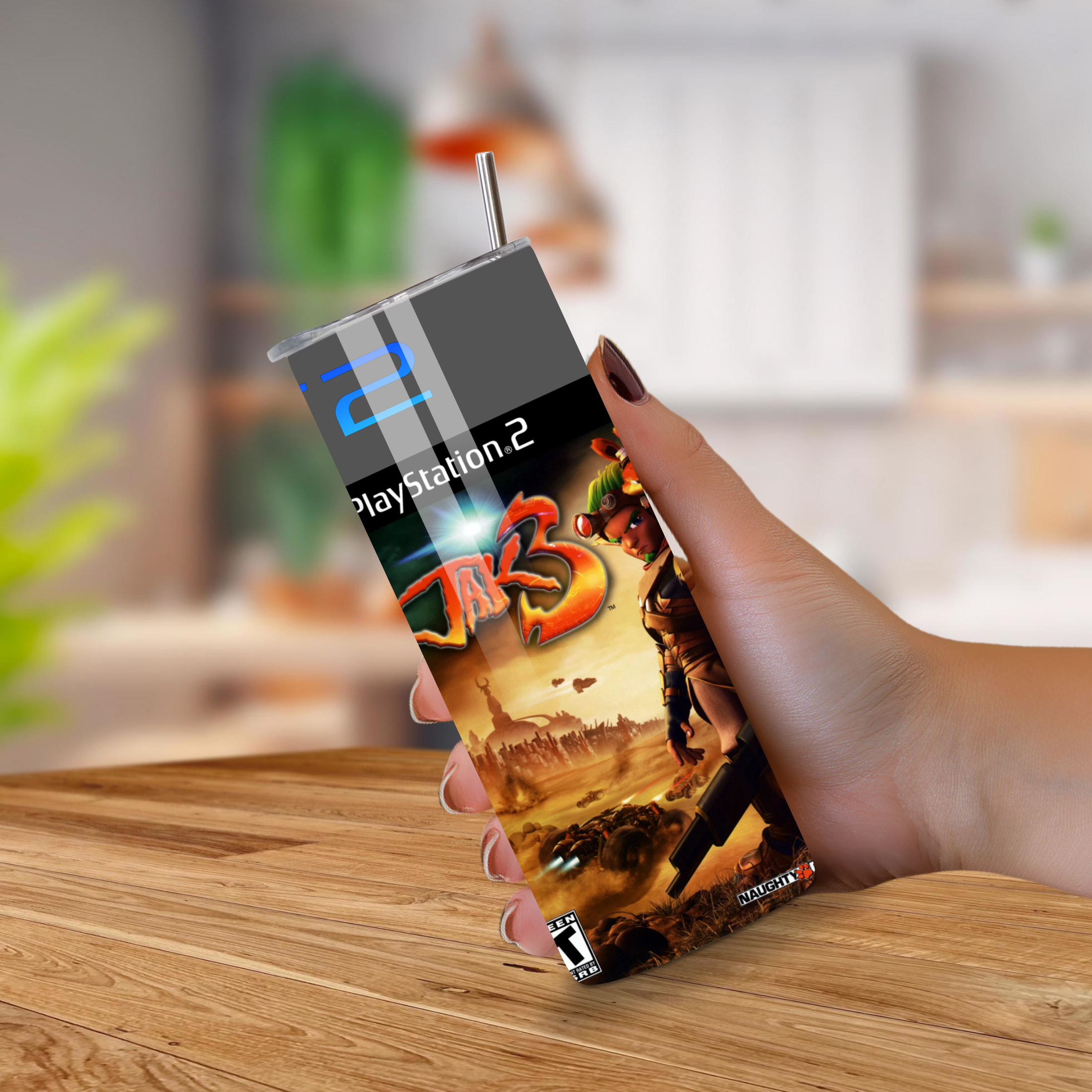Jak 3 20oz tumbler held by a hand on a wooden surface with a blurred indoor background
