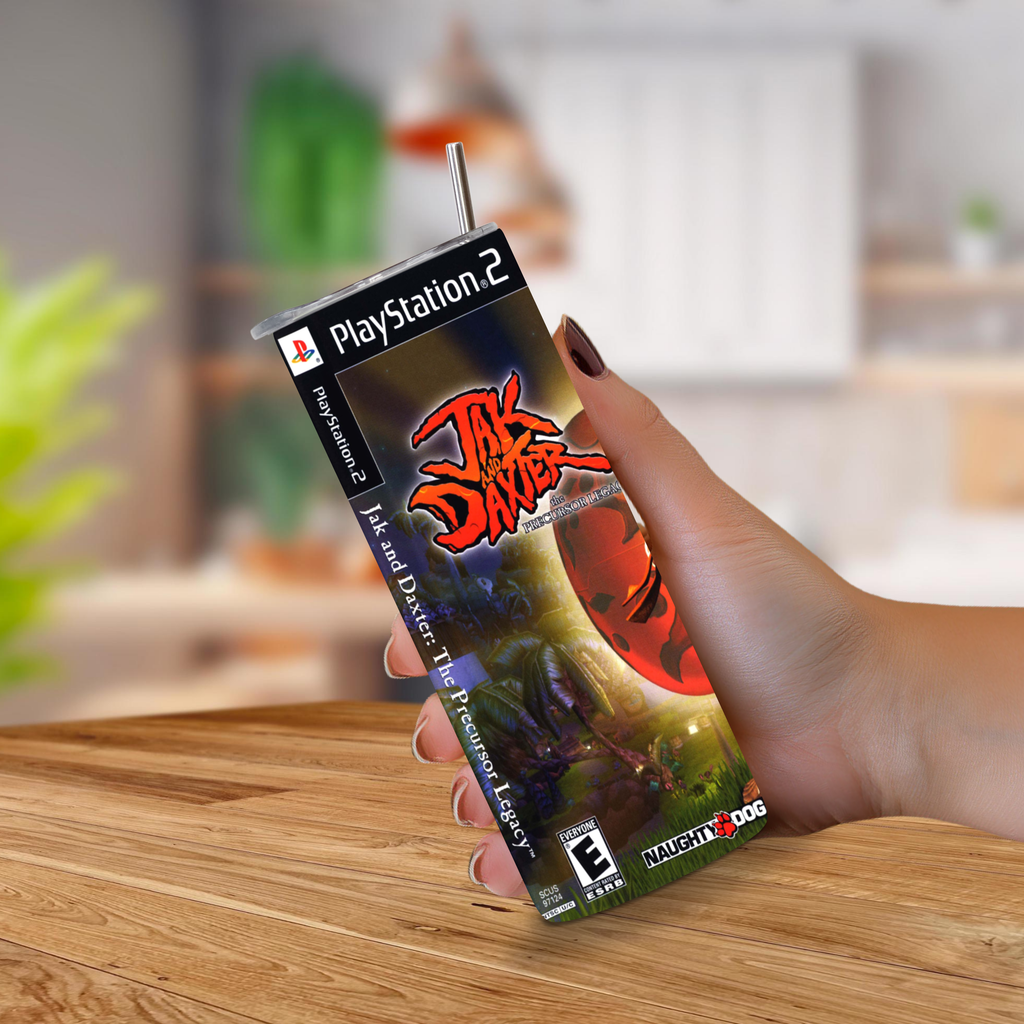 A hand holding a PlayStation 2 game case for Jak and Daxter: The Precursor Legacy, styled like a 20oz stainless steel tumbler with a straw, set against a blurred indoor background.