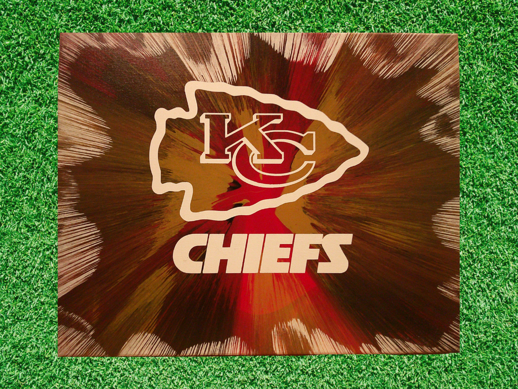 Handmade KC Chiefs Football spin art painting on a green grass background