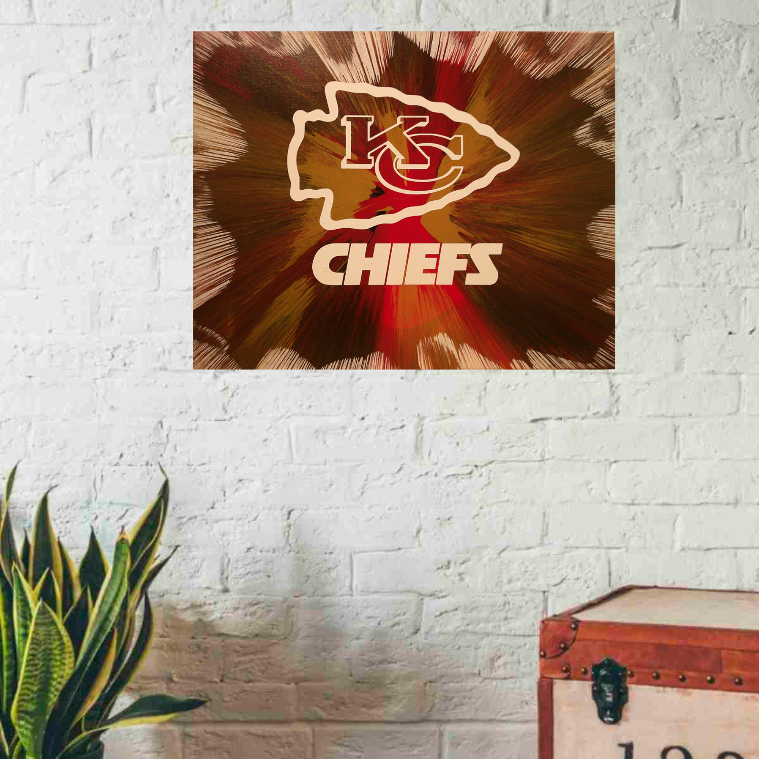 Kansas City Chiefs Spin Art on a white brick wall with a plant and suitcase.