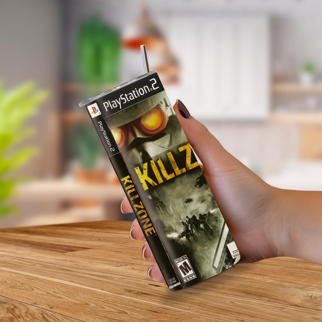 A hand holding a 20oz tumbler PlayStation 2 Killzone video game design with a metal straw, set against a blurred kitchen background.