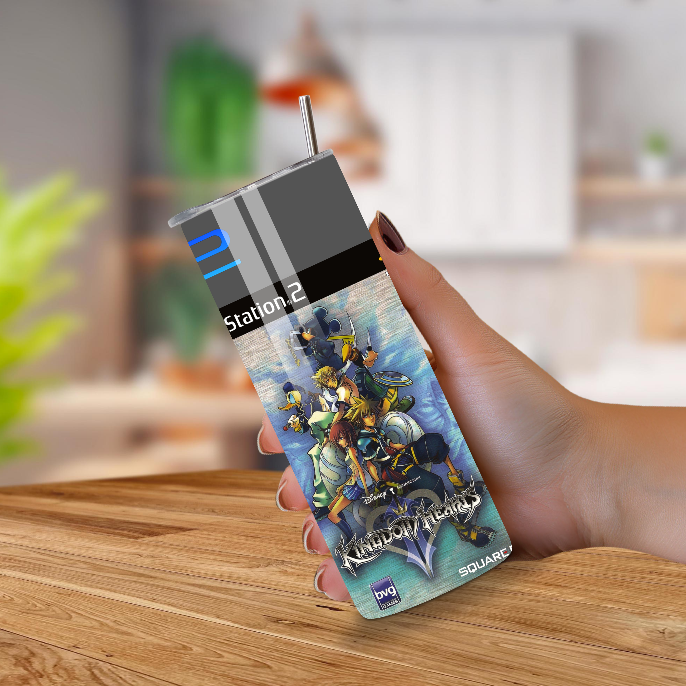 Hand holding a 20oz tumbler with a Kingdom Hearts II on a wooden surface