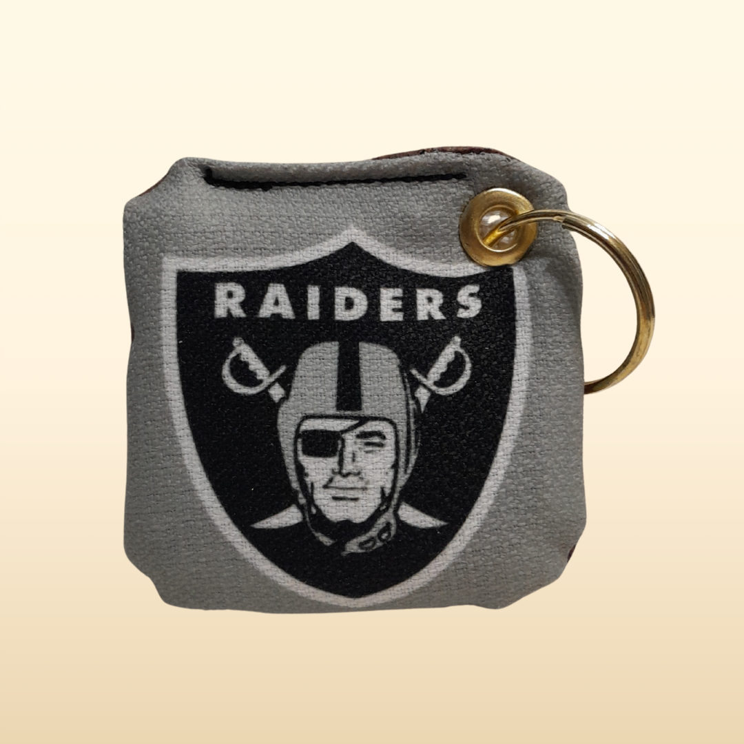 Keychain with Raiders logo on a beige background