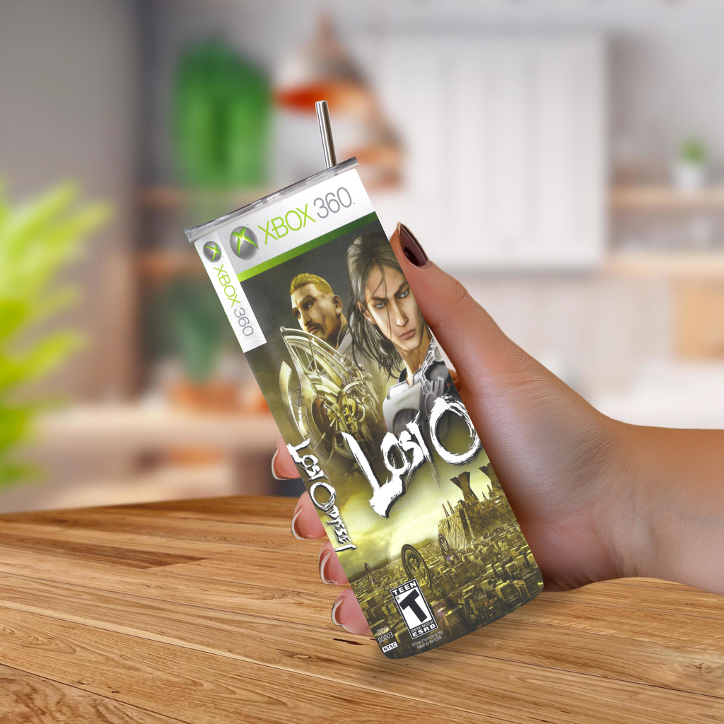 A hand holding a 20oz tumbler designed to look like an Xbox 360 game case for the video game Lost Odyssey, set against a blurred indoor background.