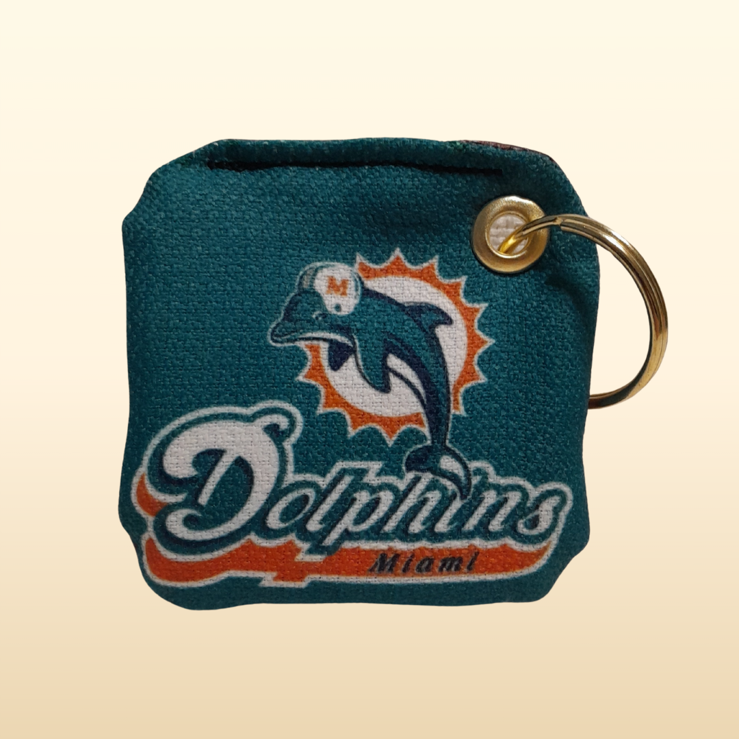 Teal keychain with Miami Dolphins logo on a beige background