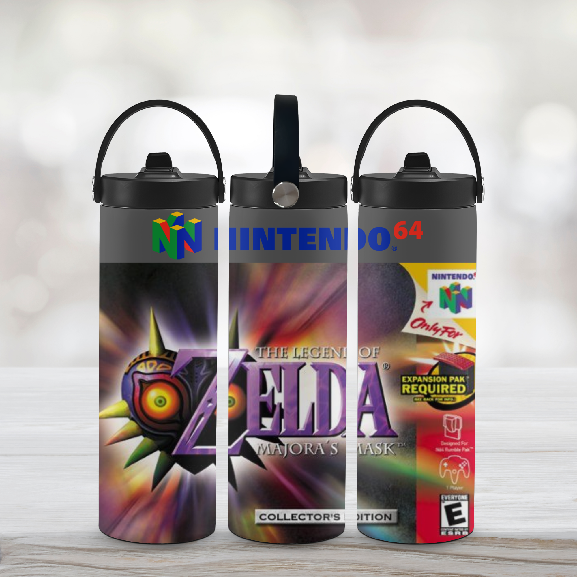 Three sports water bottle designs inspired by 'The Legend of Zelda' and majora's mask branding on a light wooden surface.