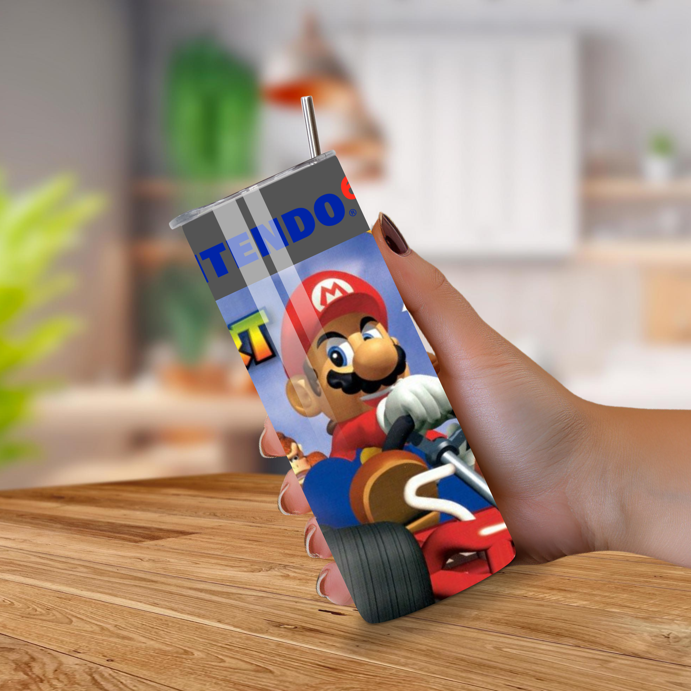 20oz tumbler with Mario kart 64 design held by a hand on a wooden surface