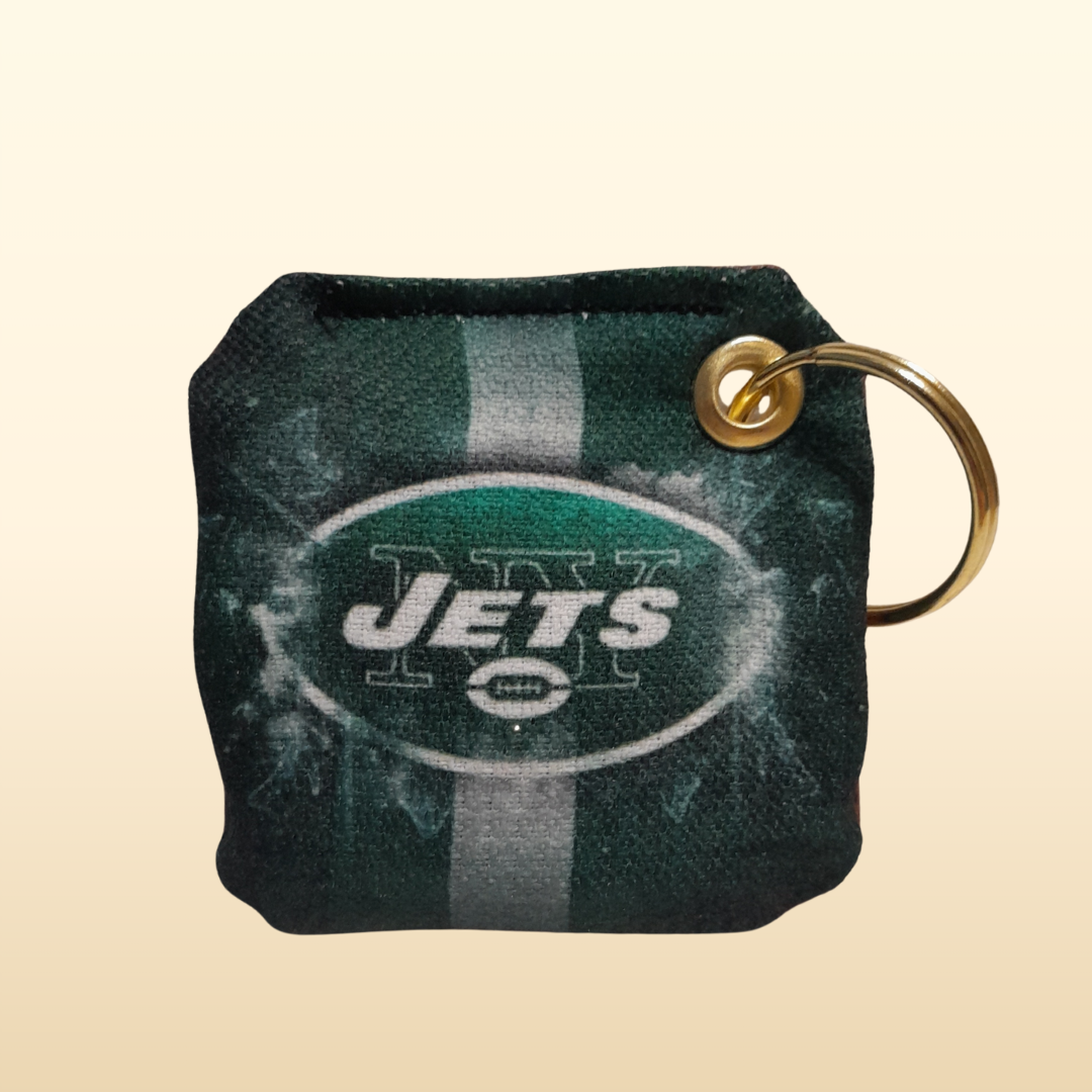 Keychain with 'NY Jets' logo on a beige background