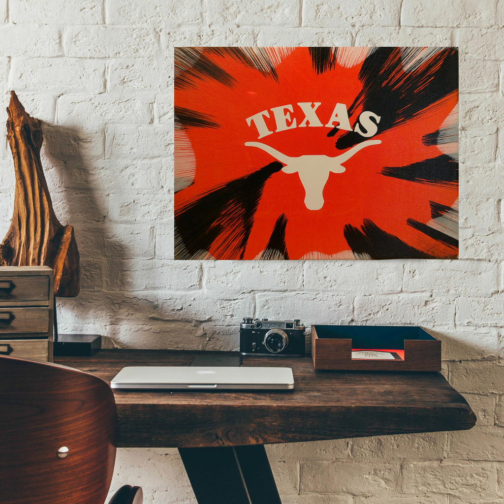 Texas Longhorn Spin Art on a white brick wall with a desk. 